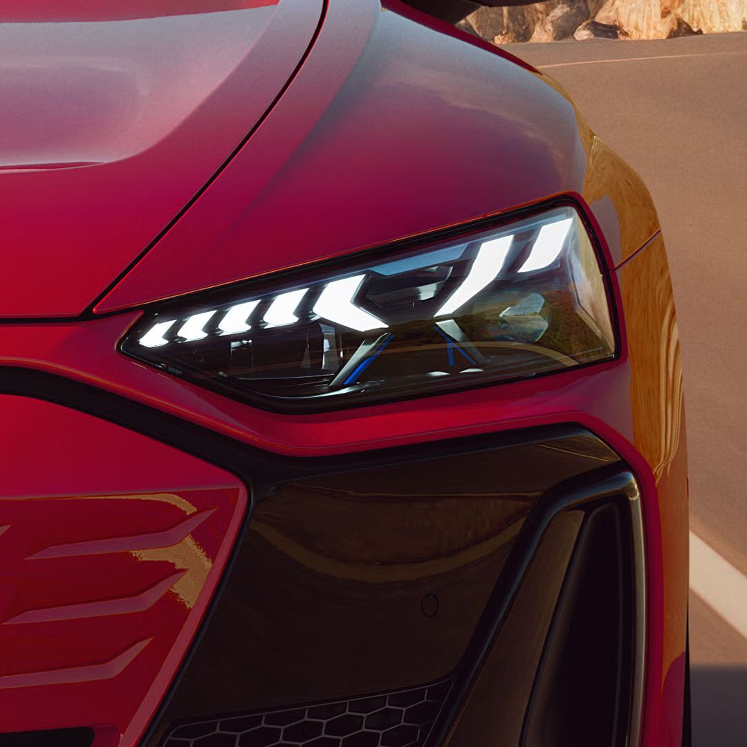 Nahaufnahme des Matrix LED-Scheinwerfer eines roten Audi e-tron GT quattro.
