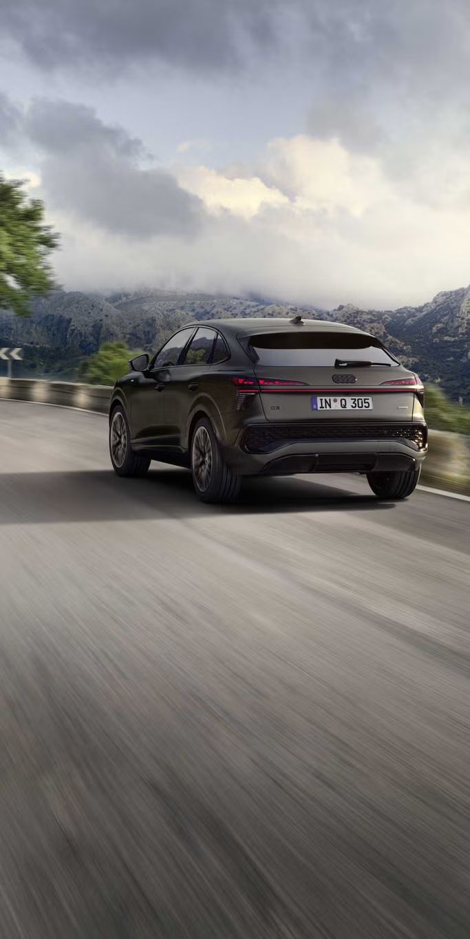 Dynamische Fahraufnahme eines Audi Q3 Sportback in bergiger Landschaft