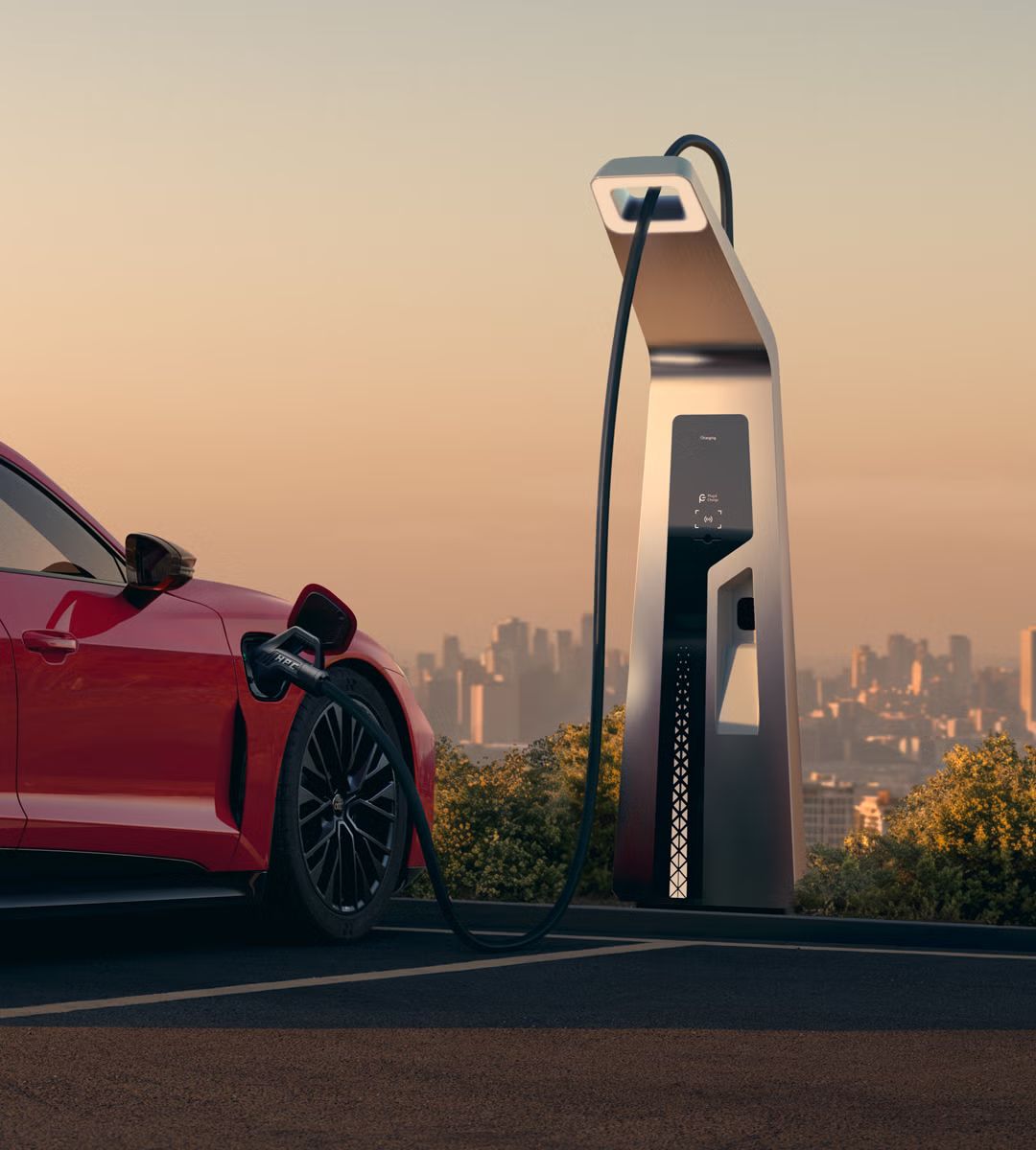 Ein roter Audi e-tron GT quattro steht auf einer Anhöhe über einer Stadt, die ins Licht eines Sonnenuntergangs gehüllt ist. Das Fahrzeug wird an einer öffentlicher Ladesäule geladen.