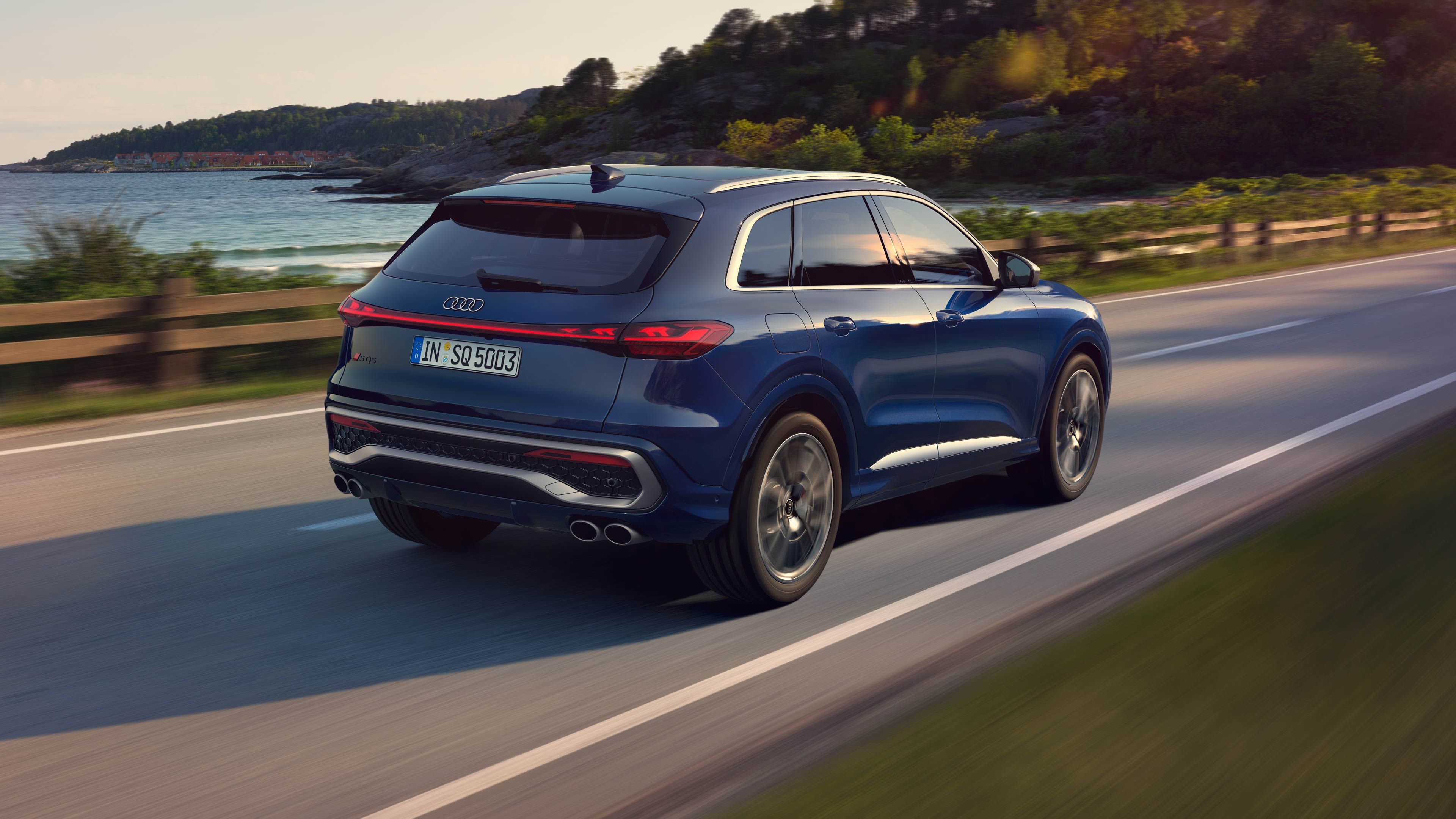 Blauer Audi SQ5 SUV in seitlicher Heckansicht beim Fahren