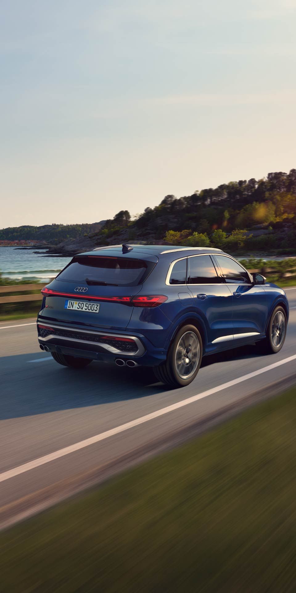 Blauer Audi SQ5 SUV in seitlicher Heckansicht beim Fahren